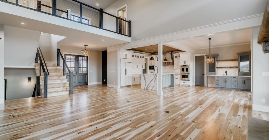 Dad pushing Daughter in Cardboard Box on Hardwood Floors