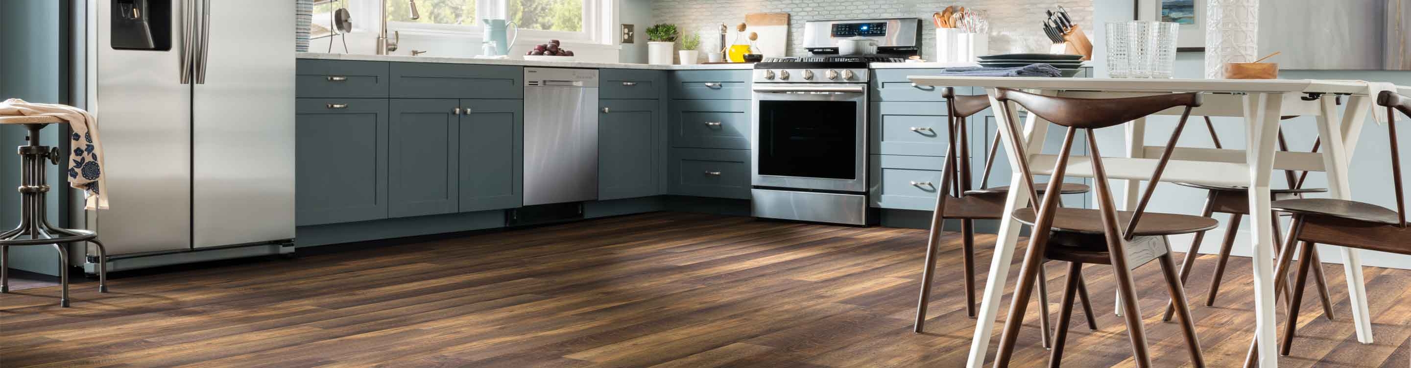 wood look flooring in kitchen with blue cabinets